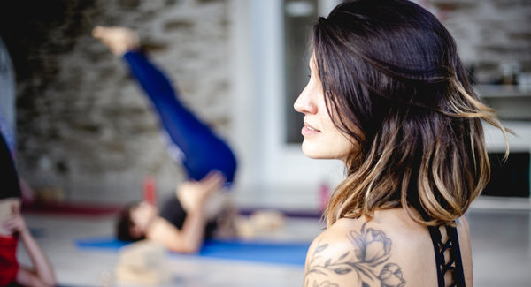 retraite yoga debutant Des élèves pratiquant le yoga dans une salle lumineuse lors d’une retraite guidée par Marie.