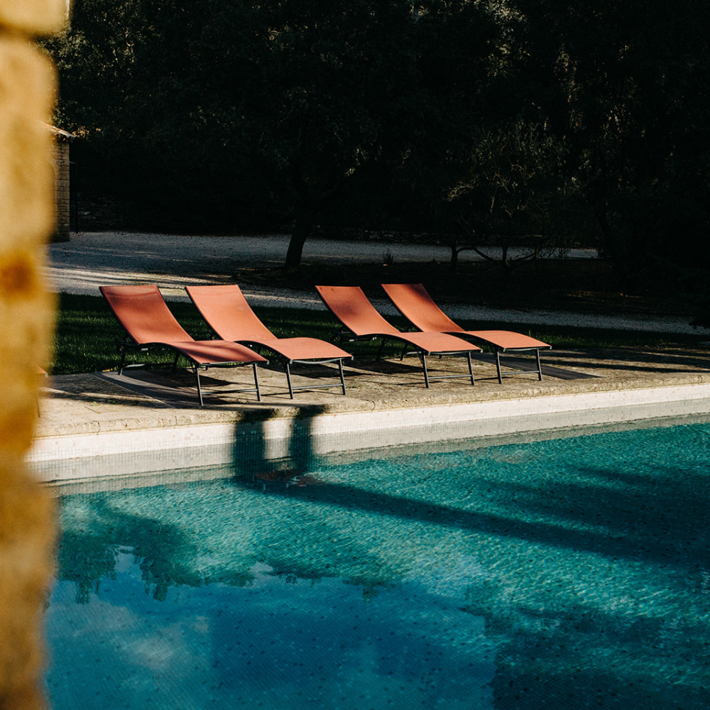 Femmes détendues sur des transats au bord d’une piscine, ambiance de retraite yoga